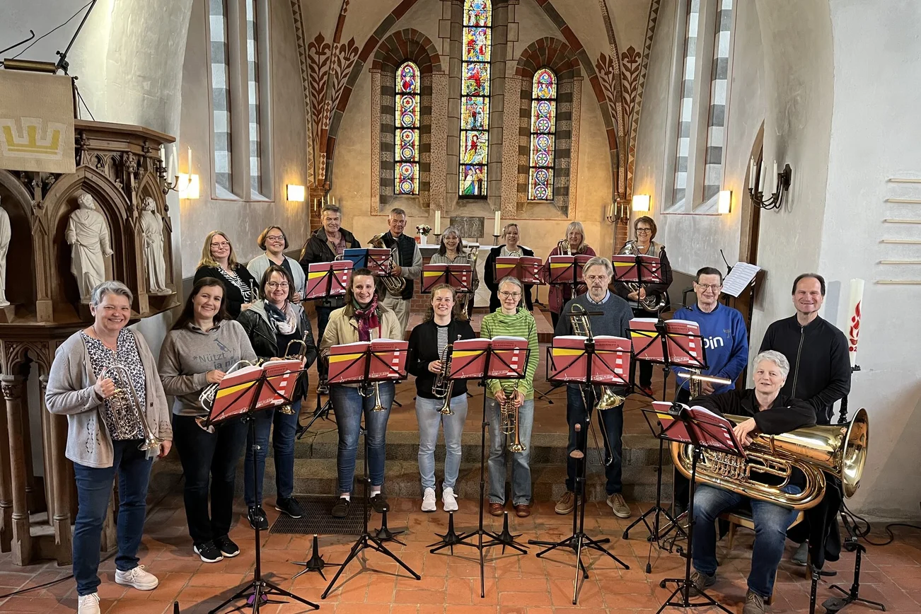 Ein großer Posaunenchor steht in einer Kirche. 