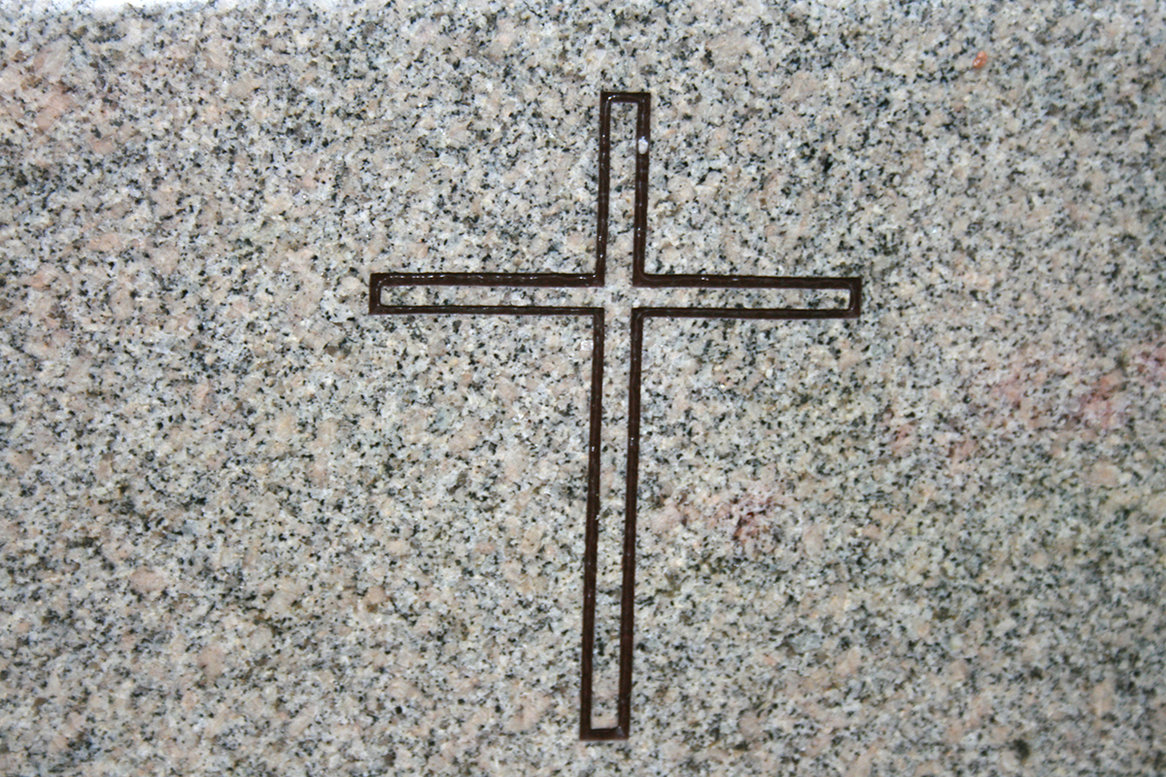 Schwarzes Kreuz auf einem Grabstein